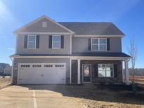 Two-story house with gray siding, stone accents, and a two-car garage at 107 Wilderness Ct, Mebane, NC 27302