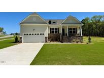 Beautiful single-Gathering home features attached two-car garage, stone accents, and manicured lawn at 19 Covey Rise Way, Lillington, NC 27546