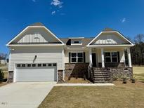 Charming home with a two-car garage, stone accents, and inviting front porch at 19 Covey Rise Way, Lillington, NC 27546