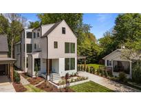 Modern two-story home featuring a unique design with large windows and beautifully landscaped front yard at 339 1/2 Mulberry St, Raleigh, NC 27604