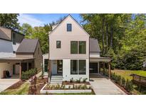 Modern two-story home featuring a light beige upper level and a white first floor with beautiful landscaping at 339 1/2 Mulberry St, Raleigh, NC 27604