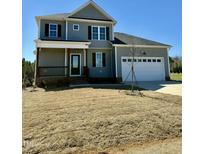 Two-story home with a front porch, two-car garage, and neutral-colored siding, all under a clear blue sky at 40 Misty Mountain, Spring Hope, NC 27882