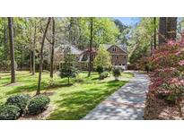 Charming two-story brick home with a lush green lawn and mature trees at 5317 Burning Oak Ct, Raleigh, NC 27606