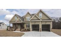 Two story house with three car garage, stone accents and covered porch at 6737 Dwight Rowlad Rd, Willow Springs, NC 27592