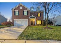 Brick two-story house with a white garage door and manicured lawn at 900 Blue Thorn Drive Dr, Apex, NC 27539