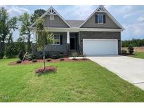 Charming home featuring a stone facade, well-maintained lawn, and a two-car garage at 114 Arundel Dr, Archer Lodge, NC 27527