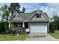 Charming single-story home with stone accents, well-manicured lawn, and inviting curb appeal at 114 Arundel Dr, Archer Lodge, NC 27527