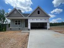 New construction home with gray siding, large windows and a spacious two car garage at 114 Arundel Dr, Archer Lodge, NC 27527