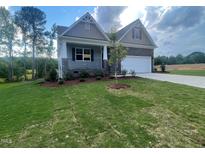 Charming home with stone accents, covered porch, landscaped yard, and a two-car garage at 114 Arundel Dr, Archer Lodge, NC 27527