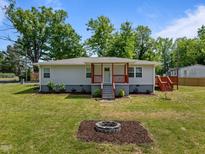Charming single-story home with a cozy front porch and a welcoming fire pit area, perfect for outdoor gatherings at 670 Mcadams Rd, Hillsborough, NC 27278