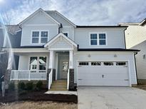 Charming two-story home with a covered front porch and a two-car garage and stone accents on the columns at 1217 Porters Call Dr, Wendell, NC 27591