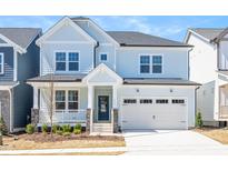 Charming two-story home with light blue siding, stone accents, covered porch, and a two-car garage at 1217 Porters Call Dr, Wendell, NC 27591