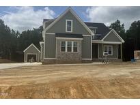 New construction two-story home featuring neutral siding and brickwork with a detached garage at 136 Bar Code Ct, Wendell, NC 27591