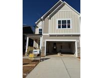 New construction home featuring a two-car garage and a covered porch, with a combination of siding and stone accents at 2476 Field Poppy Dr # 171, Apex, NC 27502