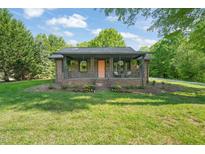 Charming brick home featuring a covered front porch, landscaped front yard, and beautiful curb appeal at 320 W Orange St, Hillsborough, NC 27278