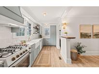 Charming kitchen features a farmhouse sink, stainless steel appliances, and bright, airy natural light at 320 W Orange St, Hillsborough, NC 27278