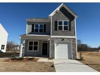 Charming two-story home features a stone-accented garage, and a manicured front lawn at 346 Tormore, Homesite 125, Sanford, NC 27330