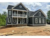 Two-story new construction home showing porch, balcony, landscaping potential, dark siding and white trim at 71 Slocum Dr, Wendell, NC 27591
