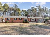 Brick ranch house with stone accents, large yard, and mature trees at 129 Jeffress Dr, Louisburg, NC 27549