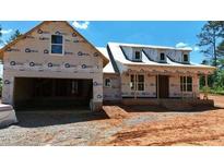 Unfinished exterior of a house with a two-car garage and dormer windows under a clear blue sky at 2850 Sheep Pasture Rd, Spring Hope, NC 27882