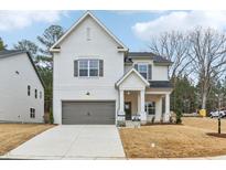 Two-story white home featuring a gray garage door and a well-manicured lawn at 3325 Oakfields Rd # 7, New Hill, NC 27562