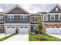 Modern two-story townhome with gray siding, stone accents, and two-car garage at 3934 Well Fleet Drive, Willow Springs, NC 27592