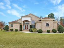 Brick home with landscaped lawn and large covered porch at 4701 Sandy Bay Cir, Raleigh, NC 27603