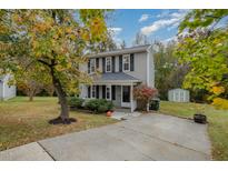 Charming two-story home featuring gray siding, black shutters, and a well-manicured front yard with mature trees at 7 Albert Ct, Durham, NC 27713