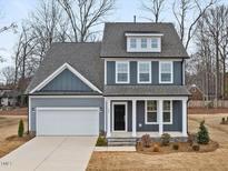 Two-story home features a two-car garage, covered front porch, and tasteful blue and gray exterior at 906 Brookfield Dr, Gibsonville, NC 27249