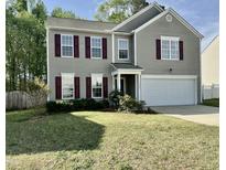 Charming two-story home with gray siding, maroon shutters, and a well-manicured lawn at 3069 Buttonwood Ln, Clayton, NC 27520