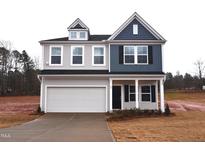 Two-story home featuring light gray siding, a two car garage, and a covered entry with white pillars at 60 Calabria Ct, Franklinton, NC 27525
