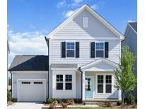 Charming two-story home with light gray siding, black shutters and a cute light blue front door at 85 Windchime Ct, Fuquay Varina, NC 27526