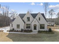 Stunning new construction white brick home with modern black trim, professional landscaping, and inviting curb appeal at 2908 Frances Marie Ln, Raleigh, NC 27603