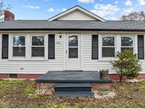 Charming home featuring a quaint front entry, complemented by classic shutters and a well-manicured lawn at 826 Carter Ave, Durham, NC 27703