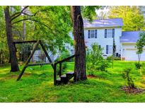 Spacious backyard with a swing set and lush green grass, perfect for outdoor activities and enjoying nature at 340 Andrews Store Rd, Pittsboro, NC 27312