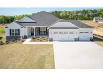Charming home with a three-car garage, stone accents, and well-maintained landscaping at 534 Glenkirk Pl # 110, Garner, NC 27529