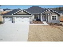 Beautiful single-Gathering home with a three-car garage and stone accents, complemented by a well-manicured front yard at 563 Glenkirk Pl # 104, Garner, NC 27529