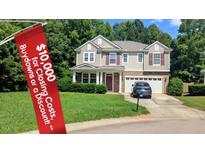 Charming two-story home with a well-manicured lawn, a two-car garage, and mature landscaping at 101 Clardona Way, Holly Springs, NC 27540