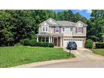 Charming two-story home with stone accents, neutral siding, red shutters, and a two-car garage at 101 Clardona Way, Holly Springs, NC 27540