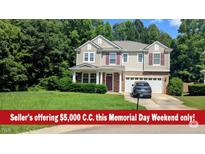 Charming two-story home featuring a well-manicured lawn and an attached two-car garage at 101 Clardona Way, Holly Springs, NC 27540