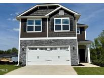 Charming two-story home featuring stone accents, a two-car garage, and classic architectural design at 211 Drayton Hall Ln, Sanford, NC 27330