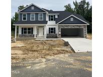 Charming two-story home with stone accents, open garage and unfinished landscaping at 69 Streamline Ct, Lillington, NC 27546