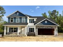 Charming two-story home with blue and white siding and a spacious two-car garage at 69 Streamline Ct, Lillington, NC 27546