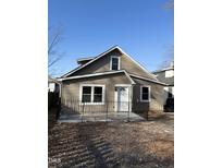 Charming single-story home featuring neutral siding, a bright white front door, and complementary black fencing at 432 N Chestnut St, Henderson, NC 27536