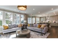 Spacious living room featuring comfortable sofas, large windows, and an open floor plan at 921 Jasper Mine Trl, Raleigh, NC 27610