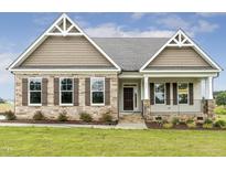 Charming single-story home with stone accents, manicured lawn, and inviting front porch at 243 Kissington Way, Benson, NC 27504