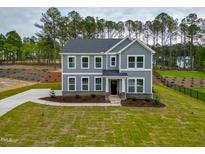 Charming gray two-story home featuring a well-manicured lawn, complemented by classic white-trim windows at 367 Duncan Creek Rd # 129, Lillington, NC 27546