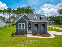 Charming single-Gathering home showcasing a stone facade, manicured lawn, and a welcoming entrance at 403 Duncan Creek Rd # 131, Lillington, NC 27546