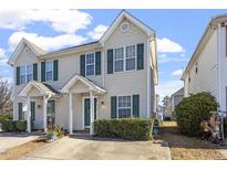 Charming townhome featuring a manicured lawn, neutral siding, green shutters, and a concrete driveway at 2248 Ventana Ln, Raleigh, NC 27604
