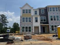 New construction townhouse exterior shows multi-pane windows, partial siding, and brick, with construction materials on the grounds at 303 Chesapeake Cmns St # 99, Garner, NC 27529